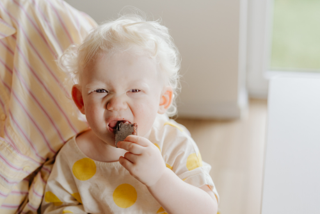 A toddler eating chocolate 