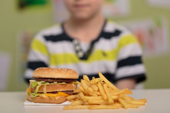 kid sitting in front of junk food
