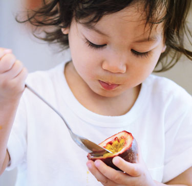 girl eating passionfruit